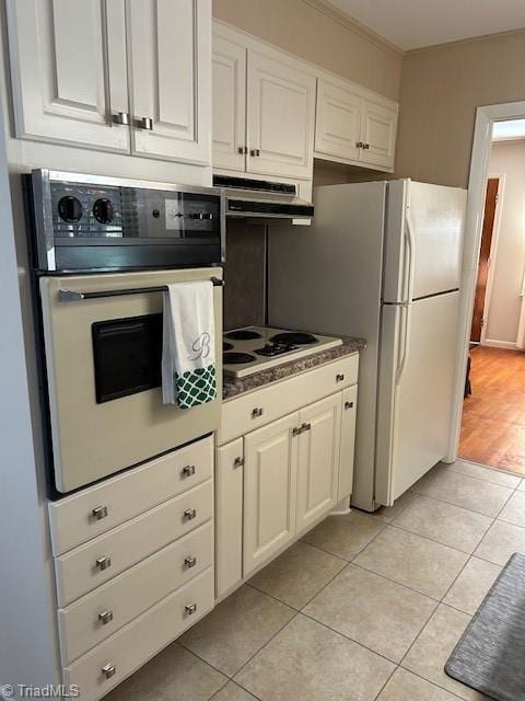 kitchen featuring ornamental molding, light tile patterned floors, white cabinets, and white appliances