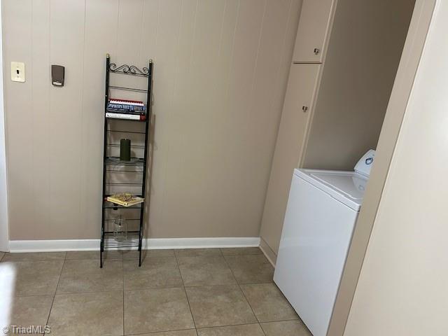 laundry area featuring washer / clothes dryer, light tile patterned floors, and cabinets