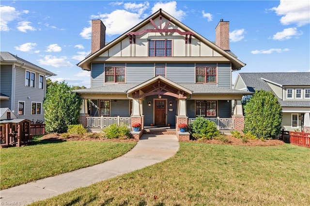 victorian house featuring covered porch, a chimney, and a front yard