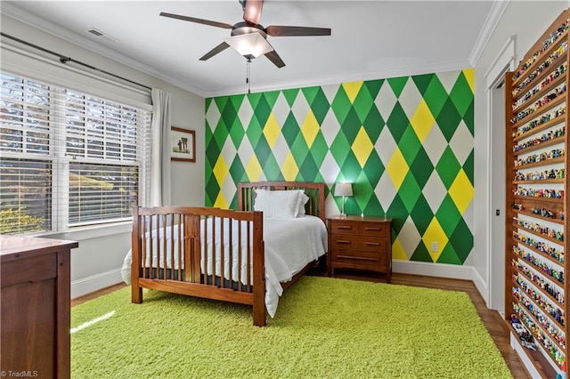 bedroom with wallpapered walls, an accent wall, baseboards, and crown molding