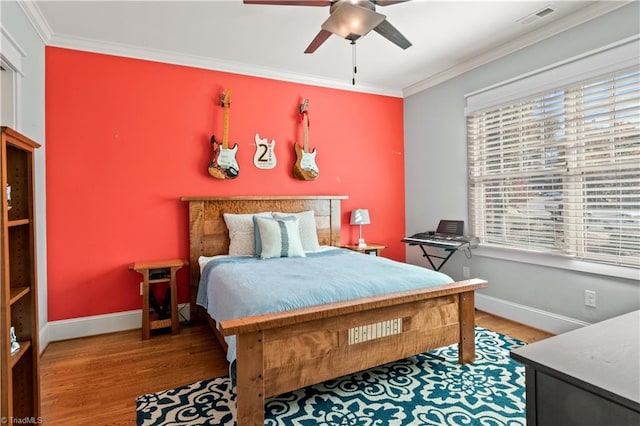 bedroom with crown molding, visible vents, and wood finished floors