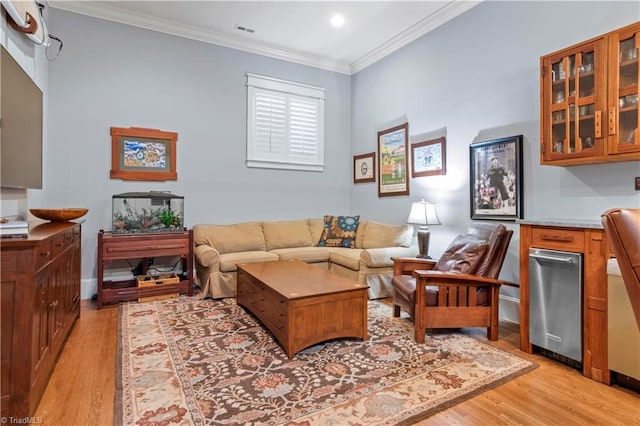 living area with light wood-type flooring, visible vents, and crown molding