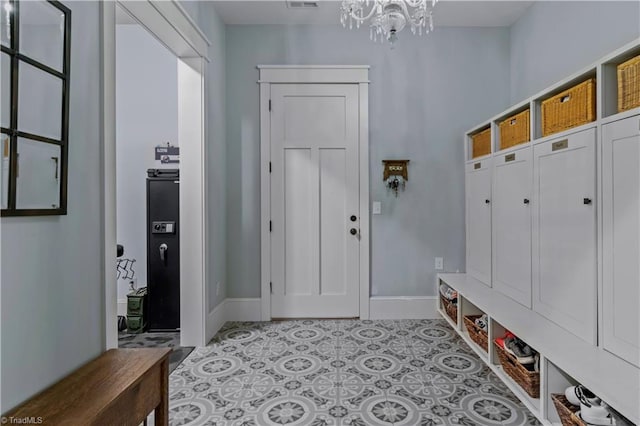 mudroom with an inviting chandelier, baseboards, and light tile patterned flooring