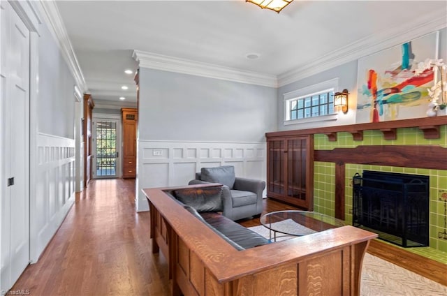 living area featuring light wood-type flooring, a wealth of natural light, and crown molding