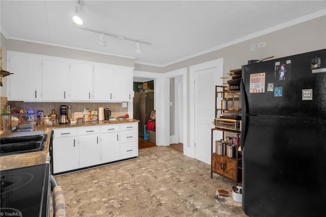 kitchen featuring rail lighting, tasteful backsplash, black refrigerator, electric stove, and white cabinets