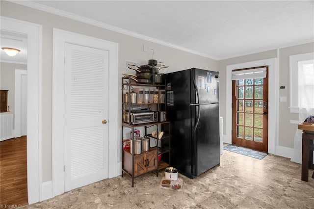 kitchen featuring ornamental molding and black fridge