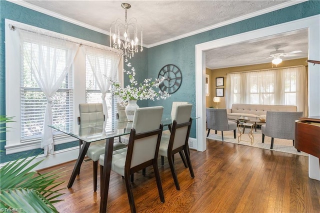 dining area with an inviting chandelier, ornamental molding, wood-type flooring, and a textured ceiling