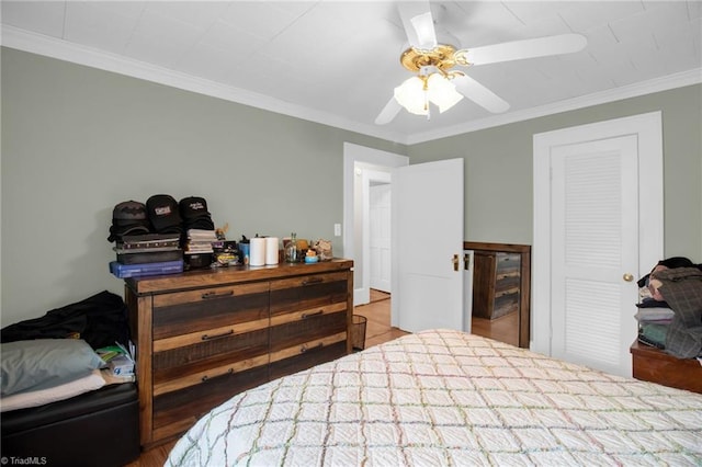 bedroom featuring crown molding, ceiling fan, and a closet