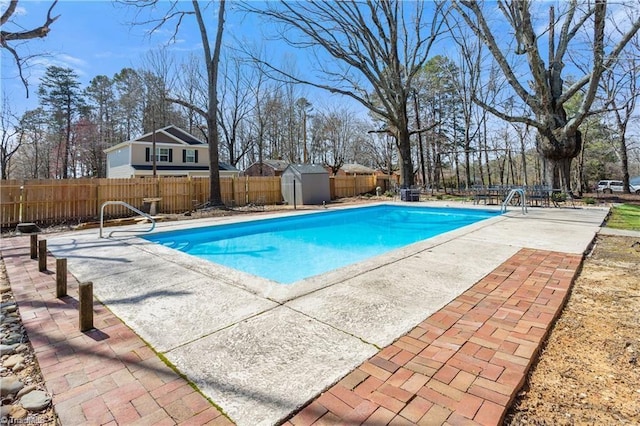 view of swimming pool featuring a shed and a patio area