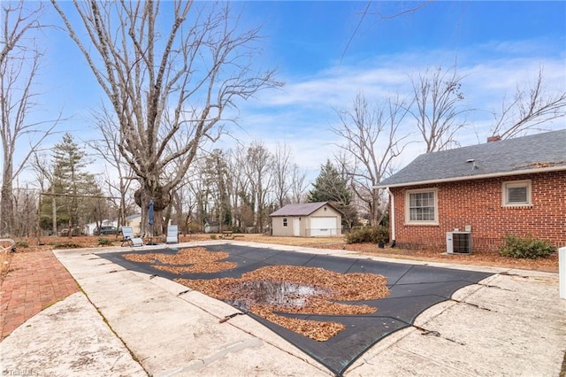 view of yard featuring cooling unit, a garage, and an outdoor structure