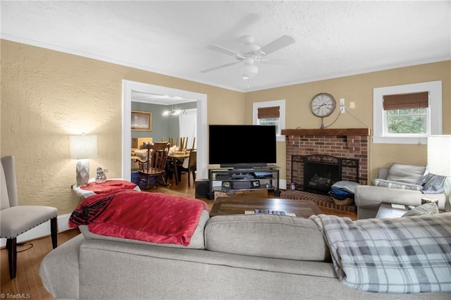 living room with ceiling fan, wood-type flooring, a fireplace, and a textured ceiling