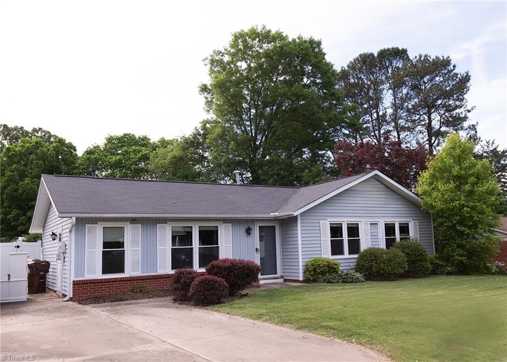 ranch-style house featuring a front lawn and brick siding
