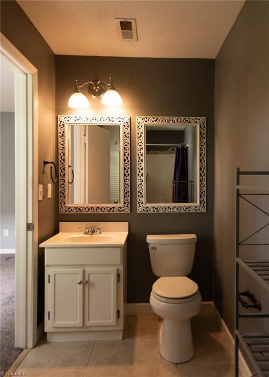 3607 Stonehurst Pl, High Point, NC 27265 - full bath featuring visible vents, tile patterned flooring, vanity, baseboards, and toilet
