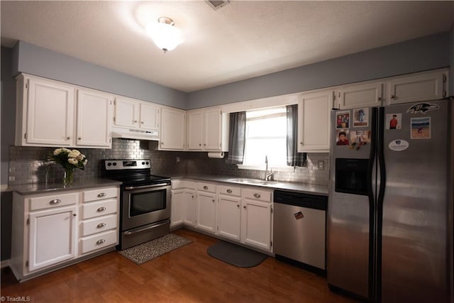 3607 Stonehurst Pl, High Point, NC 27265 - kitchen featuring tasteful backsplash, a sink, white cabinets, under cabinet range hood, and stainless steel appliances