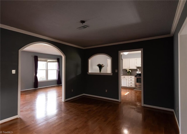 3607 Stonehurst Pl, High Point, NC 27265 - empty room with visible vents, ornamental molding, baseboards, dark wood-type flooring, and arched walkways