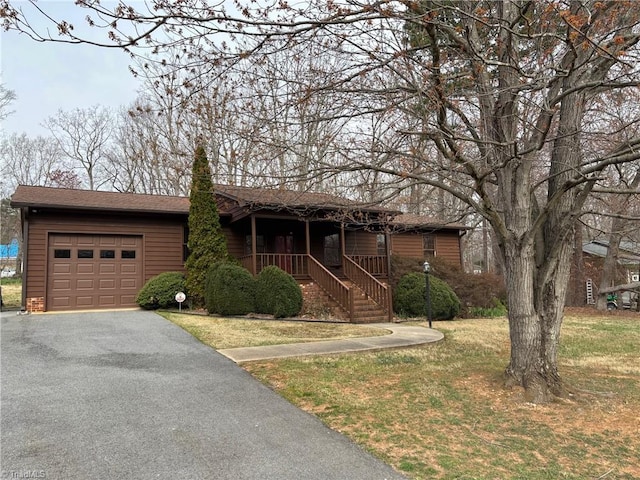 view of front of property with a front yard, a garage, driveway, and roof with shingles