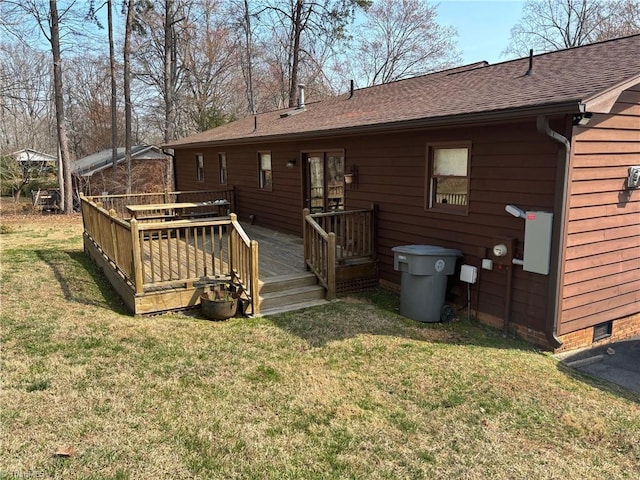 back of house featuring crawl space, a deck, a shingled roof, and a yard