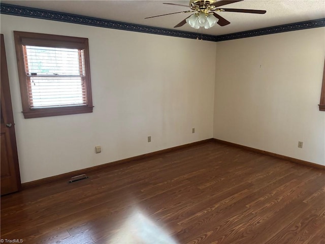 unfurnished room featuring visible vents, baseboards, dark wood-type flooring, and ceiling fan