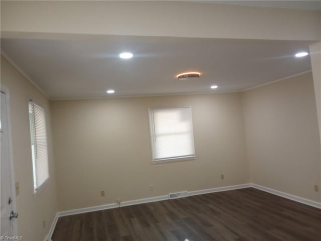 spare room with dark hardwood / wood-style flooring and ornamental molding