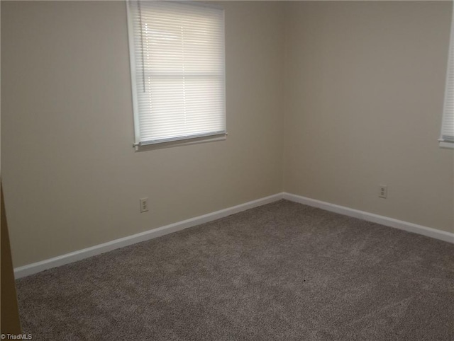 unfurnished room with dark carpet