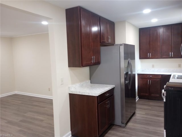 kitchen with stainless steel fridge with ice dispenser, range, light hardwood / wood-style flooring, and crown molding