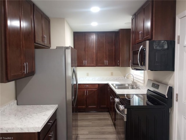 kitchen with stainless steel appliances, light hardwood / wood-style floors, and sink