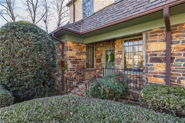 doorway to property featuring stone siding and covered porch