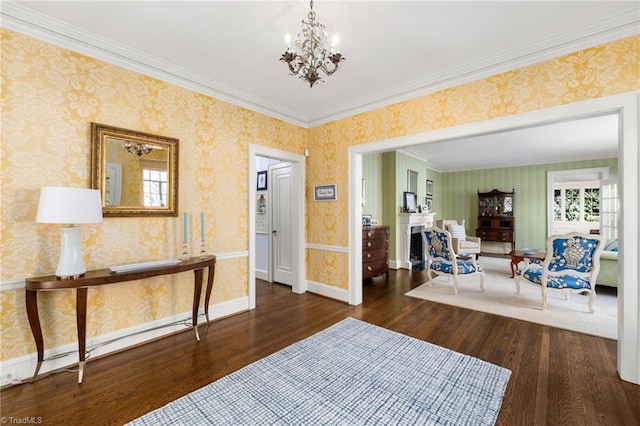 interior space with wallpapered walls, baseboards, ornamental molding, wood finished floors, and a notable chandelier