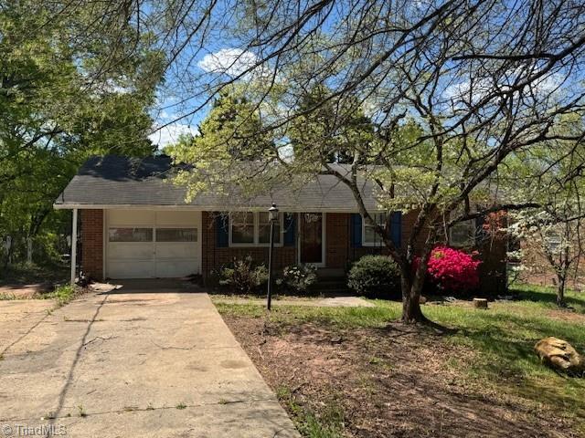 1226 Lewis St, Eden, NC 27288 - view of front of house with an attached garage, concrete driveway, and brick siding