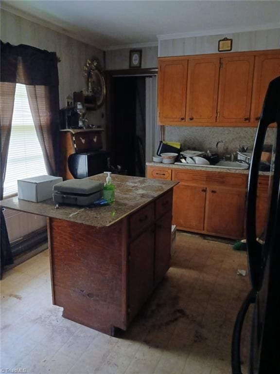 1226 Lewis St, Eden, NC 27288 - kitchen featuring light flooring, freestanding refrigerator, crown molding, light countertops, and brown cabinetry