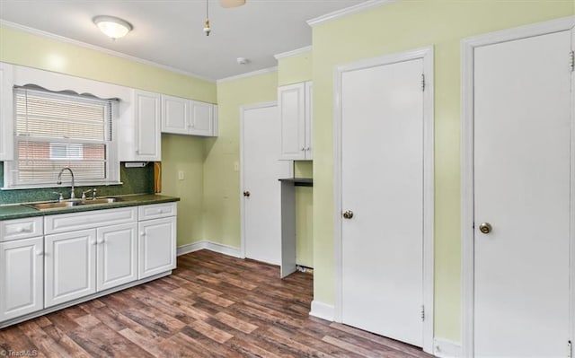 kitchen featuring sink, dark hardwood / wood-style flooring, backsplash, crown molding, and white cabinets