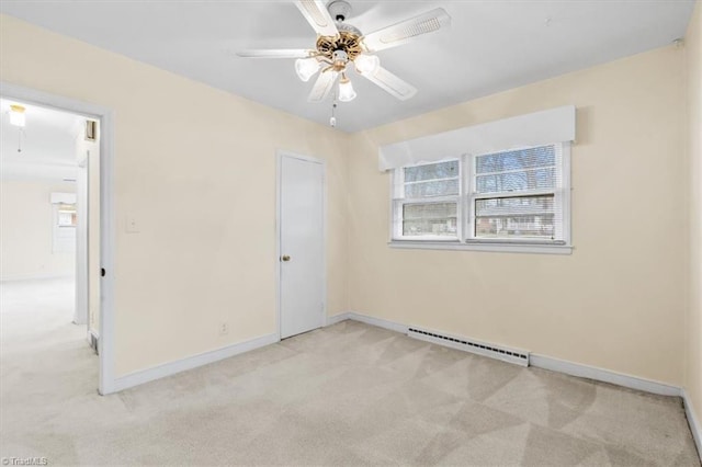 carpeted spare room with ceiling fan and a baseboard heating unit