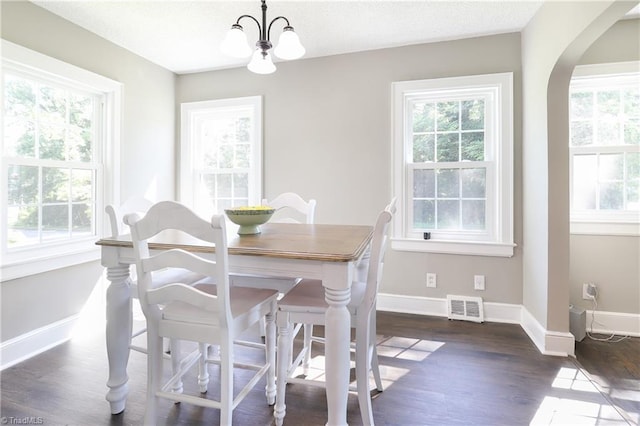 2904 Spring Garden St, Greensboro, NC 27403 - dining space with a chandelier, dark wood-type flooring, and arched walkways