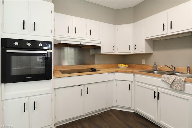 2904 Spring Garden St, Greensboro, NC 27403 - kitchen with black appliances, under cabinet range hood, light countertops, and dark wood-style floors