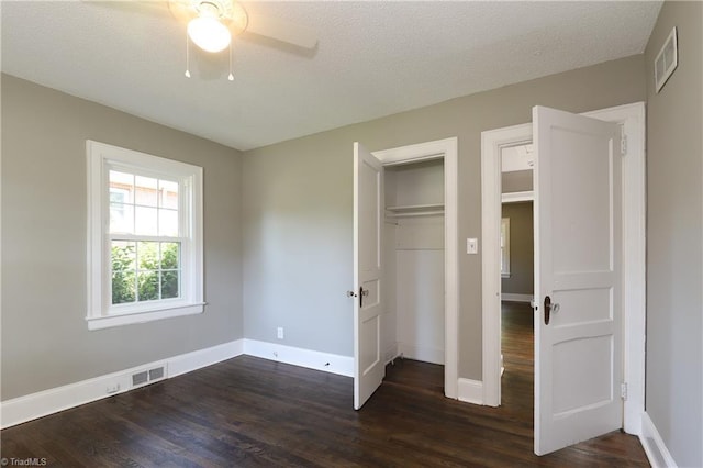 2904 Spring Garden St, Greensboro, NC 27403 - unfurnished bedroom featuring dark wood-style flooring, ceiling fan, and a closet