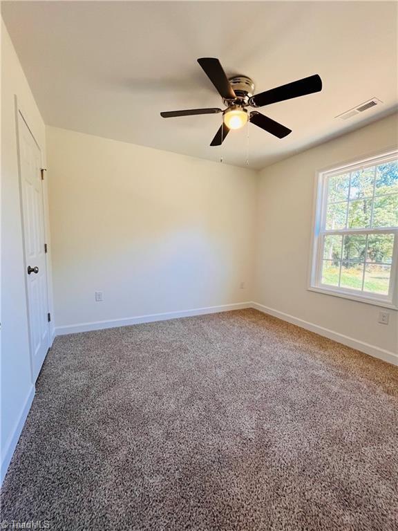 1609 Hardie St, Greensboro, NC 27403 - carpeted empty room featuring baseboards and ceiling fan