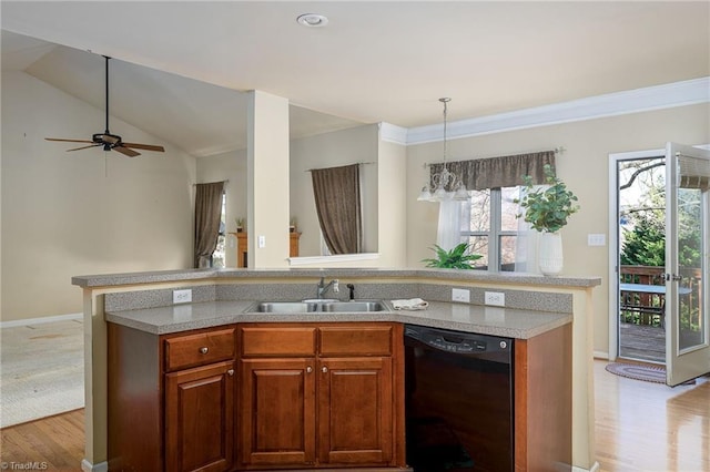 kitchen with open floor plan, light countertops, black dishwasher, hanging light fixtures, and a sink