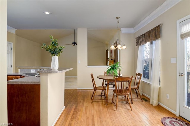 dining area with light wood-style flooring, ceiling fan, baseboards, and vaulted ceiling