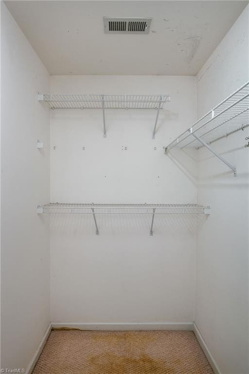 walk in closet with visible vents and light carpet