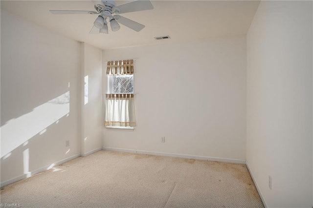 carpeted empty room featuring visible vents, baseboards, and ceiling fan