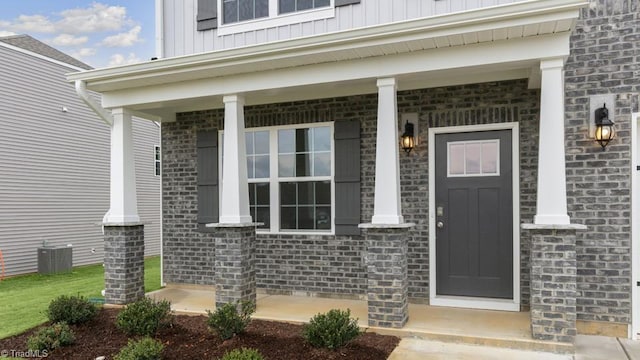 2867 Burgess Dr, Mebane, NC 27302 - view of exterior entry featuring board and batten siding, covered porch, brick siding, and cooling unit