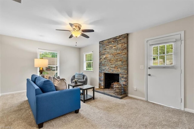 carpeted living area with ceiling fan, baseboards, and a fireplace