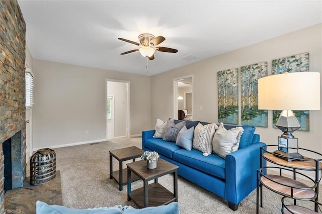 carpeted living room with a ceiling fan, a fireplace, and baseboards