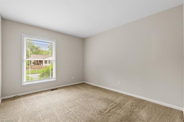carpeted spare room featuring baseboards