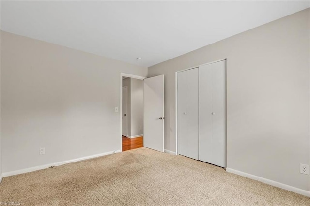 unfurnished bedroom with carpet, baseboards, and a closet