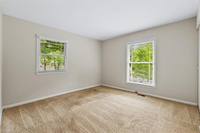 carpeted empty room with baseboards