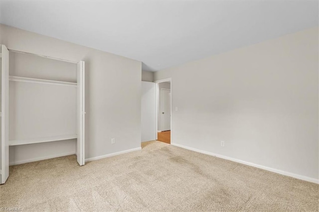 unfurnished bedroom with carpet, baseboards, and a closet