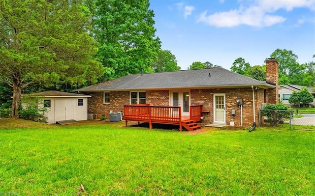 back of property with a chimney, a wooden deck, a shed, an outbuilding, and brick siding