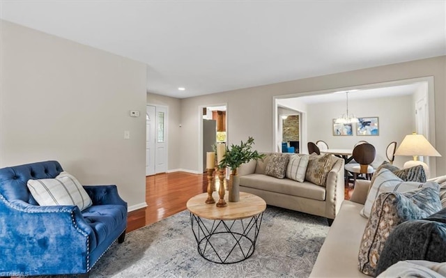 living area featuring a chandelier, wood finished floors, baseboards, and recessed lighting
