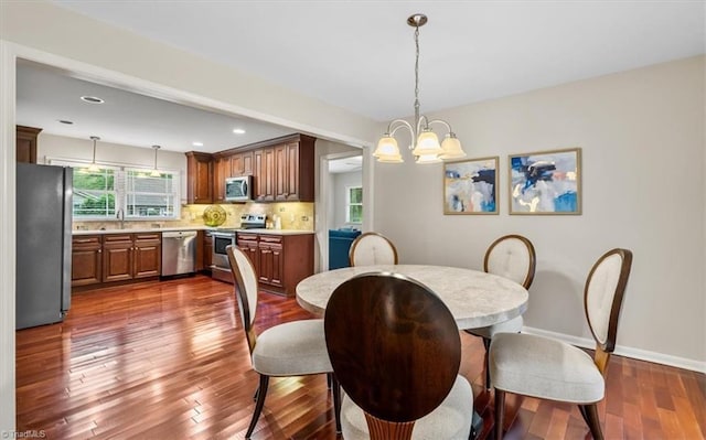 dining space with a chandelier, dark wood-style flooring, baseboards, and recessed lighting